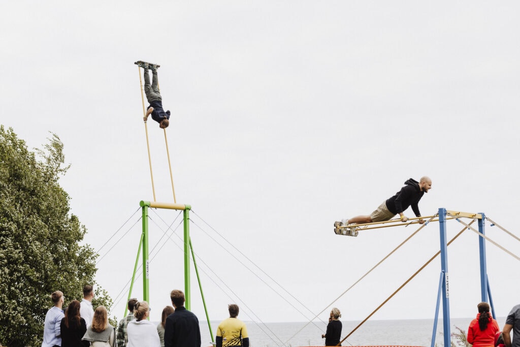 kaks meest kahel eraldi kiikingu kiigel kiikumas ning rahvas vaatamas