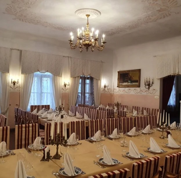 Pildil on näha Cantervilla lossi ballisaali kaetud laudadega ja punase-valge triibuliste toolidega