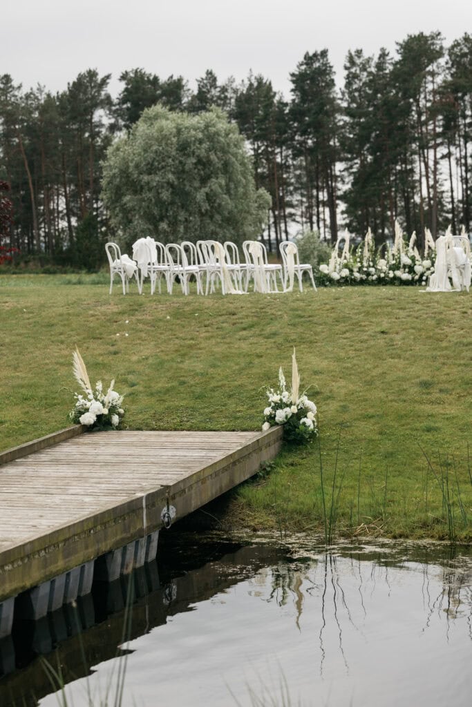 Pildil on sild, mis viib Kõltsu mõisa alal toimunud tseremooniakohta, kus on valged toolid ja lilleseade