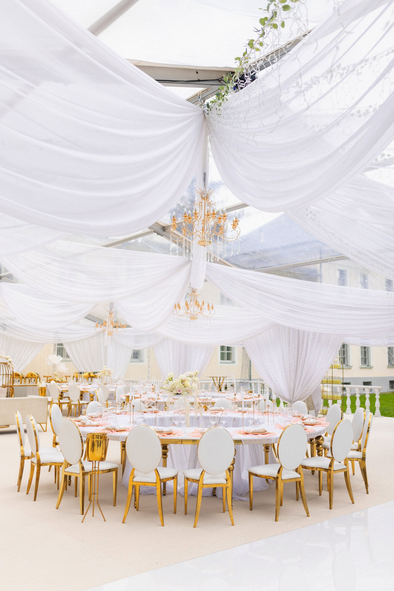 Valgete kangaste ja lühtritega kaunistatud pulmatelk Kernu mõisa aias.