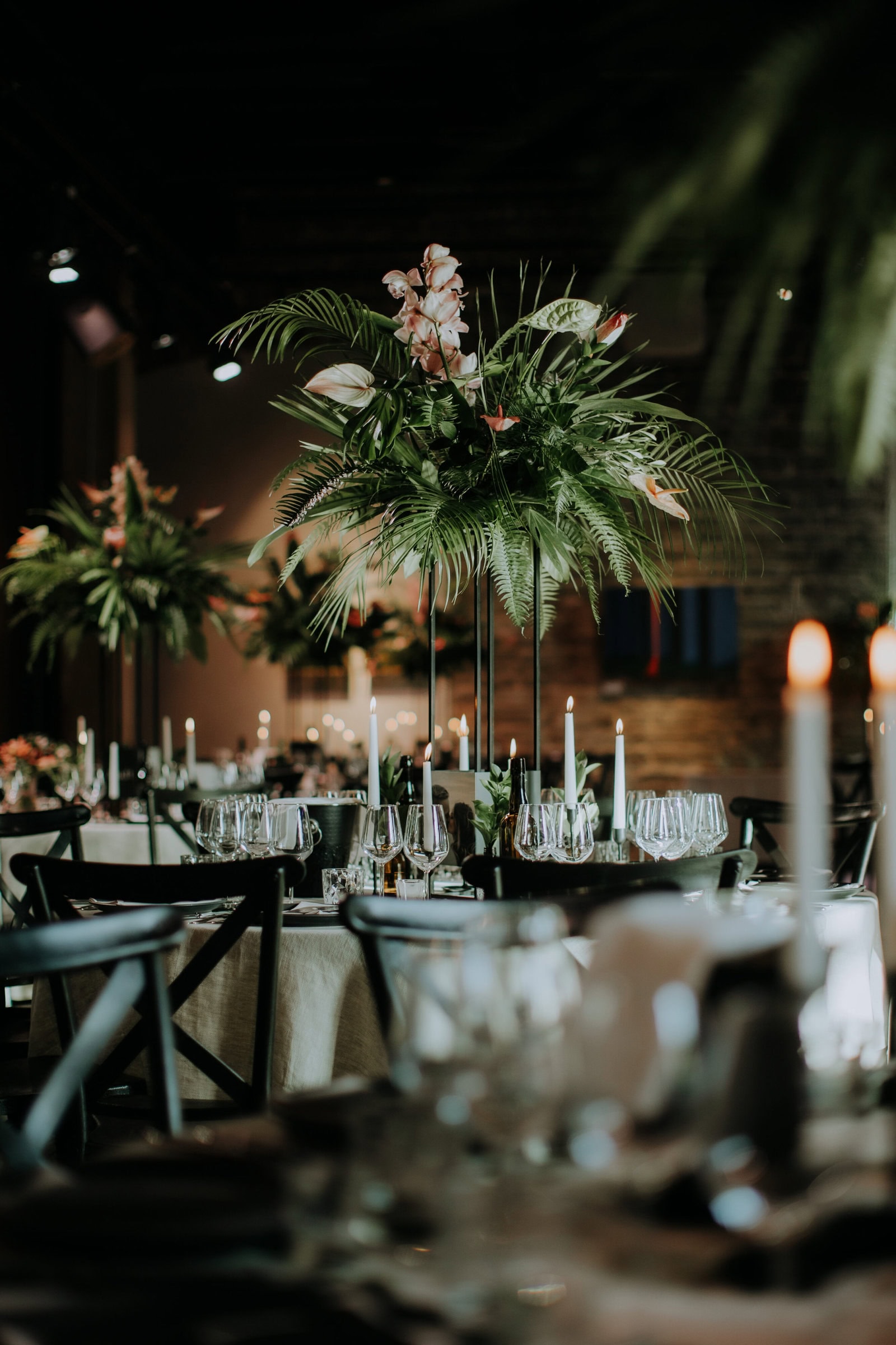 Pildil on Fotografiska saalis asetsevad pulmalauad modernsete dekoratsioonidega, uhke lilleseadega