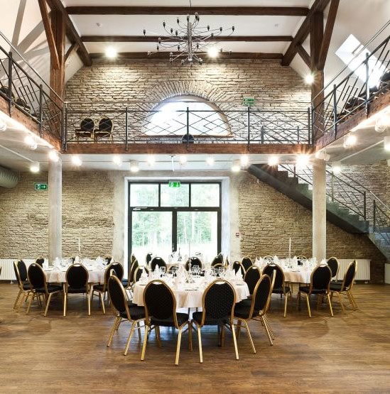 Pildil on Vihula mõisa peosaal pulmadeks ja muudeks üritusteks, saali keskel ümmargused lauad ja nende ümber on toolid