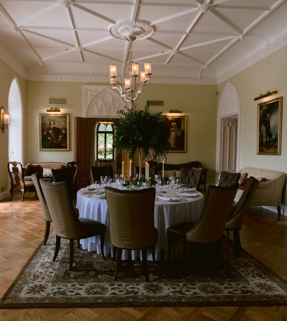 The event hall at Keila-Joa Schloss Fall, decorated for a wedding, featuring a tall fern floral centerpiece.