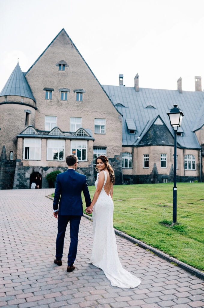 The couple taking wedding photos in front of Wagenküll Castle on their wedding day.