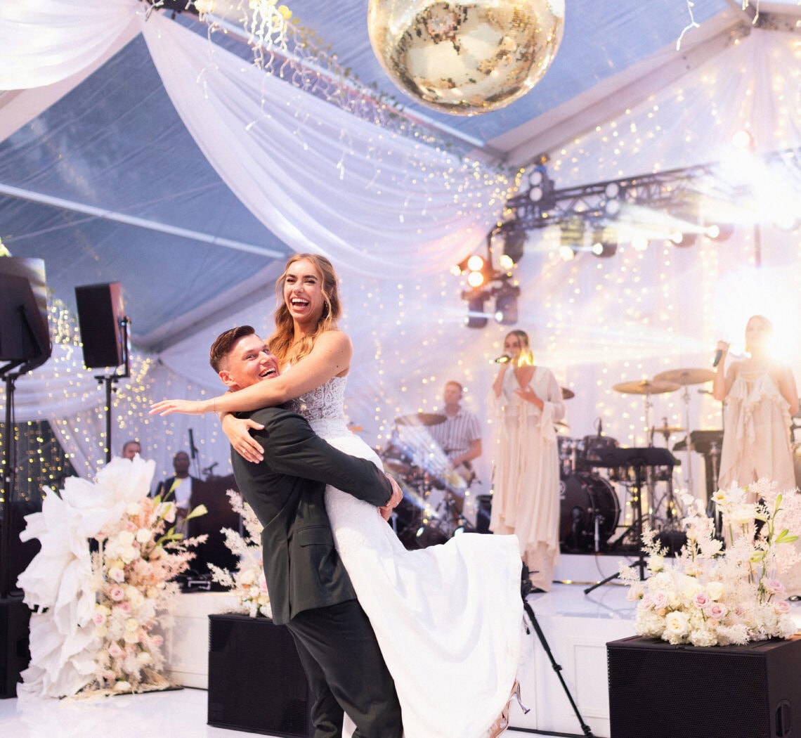 Pruut Ann Metsaots-Sepp ja peigmees Henrik Sepp tantsimas avatantsu valges pulmatelgis.